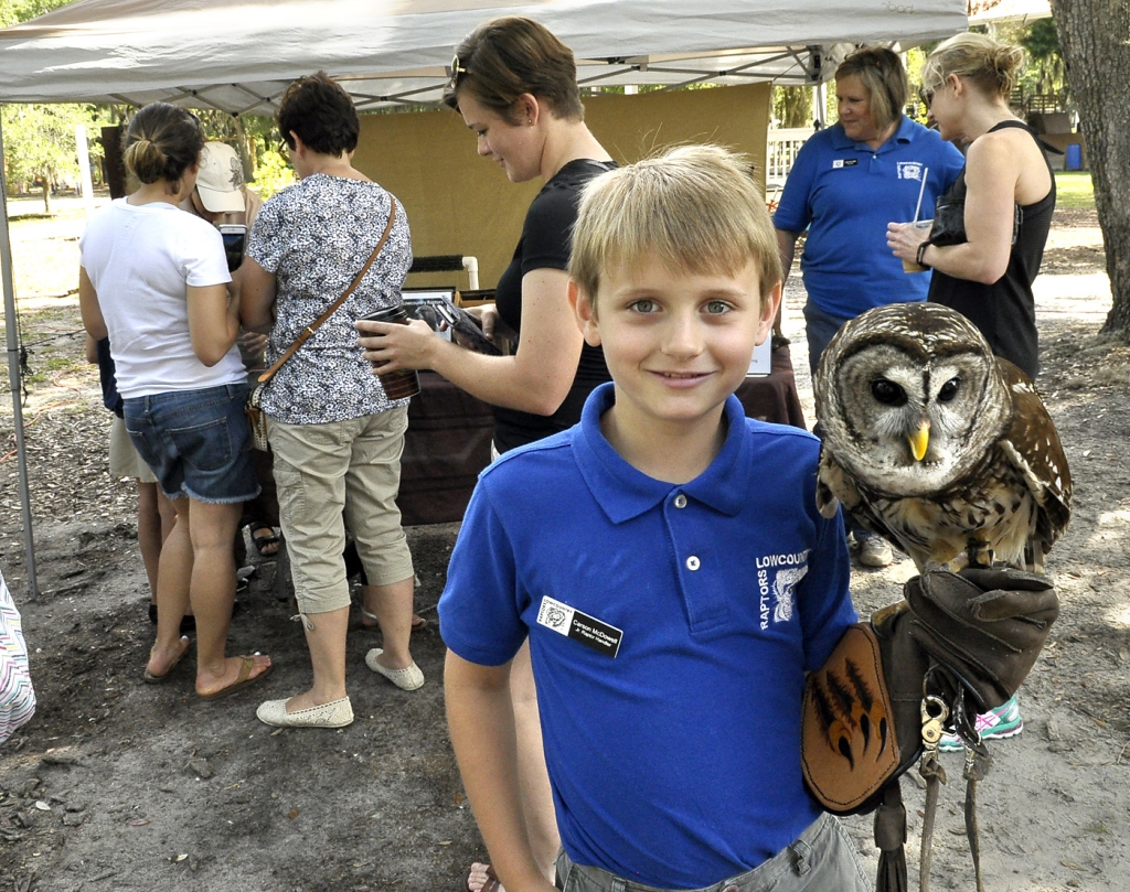 Carson McDowell, a junior raptor handler with the Lowcountry Raptors, holds Breezy, a 2-year-old Barred Owl, during the Port Royal Farmer's Market. The Lowcountry Raptors had several different owls on display.