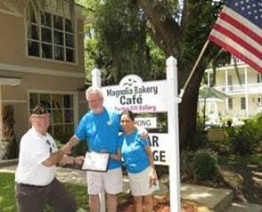 American Legion Beaufort Post 9 is striving to promote both patriotism and businesses in the Beaufort area by calling attention to those that proudly display the U.S. flag at their location. Post 9 presents those enterprises with a framed certificate thanking them. Here, Dana and Jing Johnsrude of Magnolia Bakery accept a certificate from Post Commander Chuck Lurey.