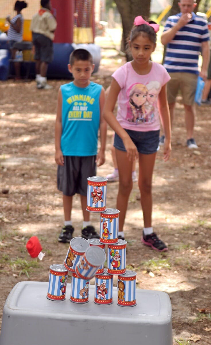 Janelle Rodriguez, 9, right, knocks down the pyramid of cans to win a prize during Military Appreciation Day. Janelle’s dad is a drill instructor at Marine Corps Recruit Depot Parris Island.