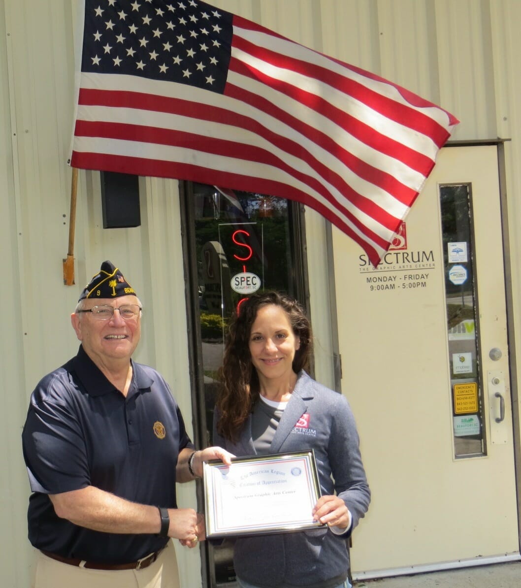 American Legion Beaufort Post 9 is striving to promote both patriotism and businesses in the Beaufort area by calling attention to those that proudly display the U.S. flag at their location. Post 9 presents those enterprises with a framed certificate thanking them. Here, Terri Ely of Spectrum Graphic Arts accepts a certificate from Post Commander Chuck Lurey.