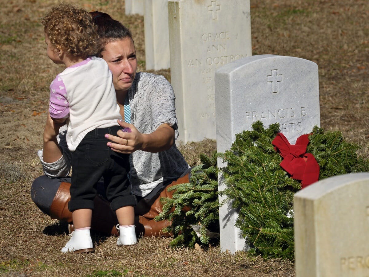 Johanna Roberts holds her 19-month-old daughter Marleigh Beam during the Wreaths Across America at Beaufort National Cemetery.
