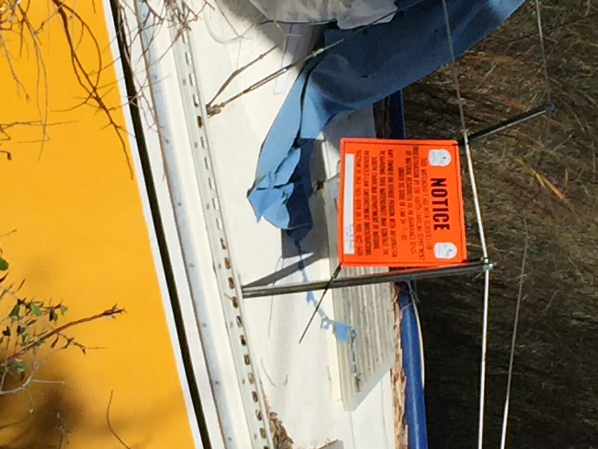 Abandoned boats have an orange sign posted by the South Carolina Department of Natural Resources asking for information regarding the owners of the vessels. The phone number is 800-922-5431.