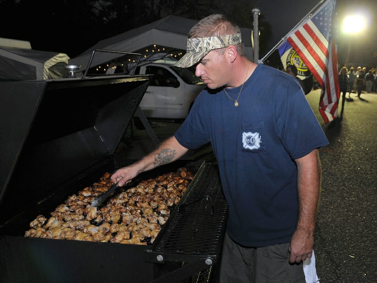 Allen Kincheloe off the Ashley River Fire Department’s “River Rats” BBA team, turns the chicken wings during the annual Bands, Brews & BBQ.
