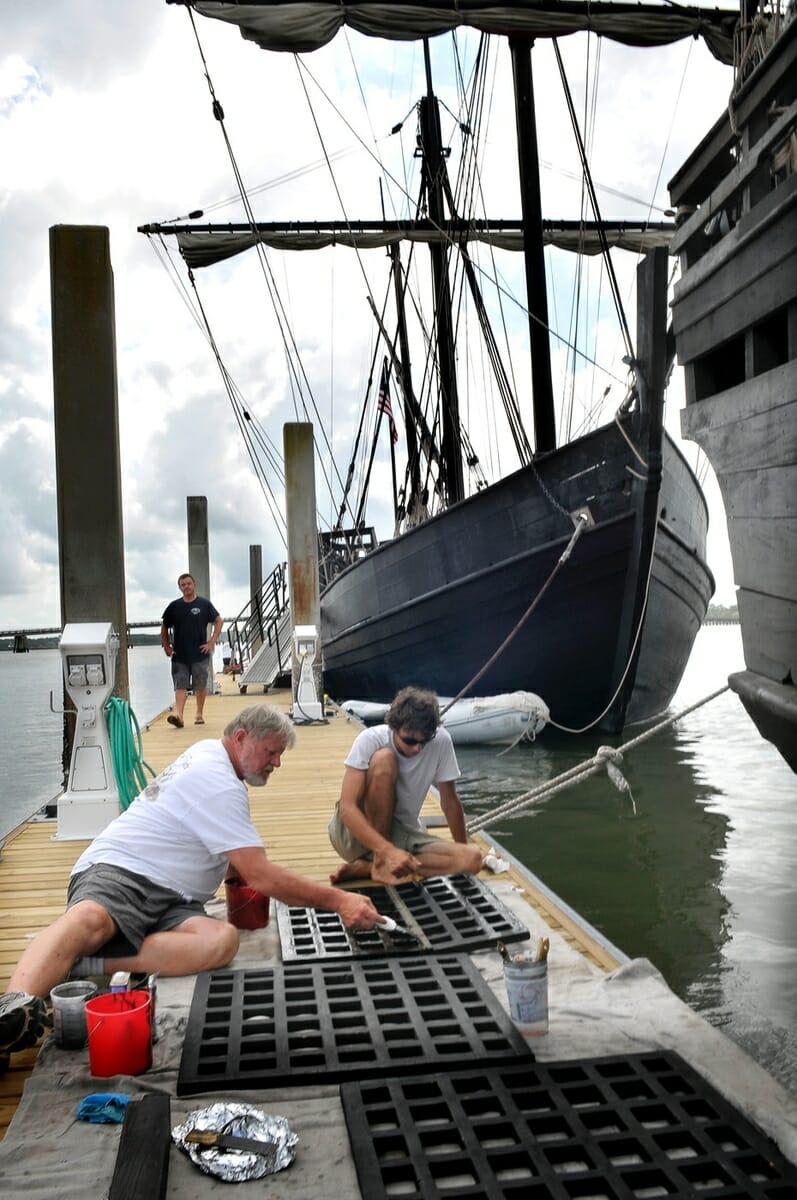 Crewmen add stain to the deck hatches. One crew member said there is always something to do aboard the replicas of Christopher Columbus’ ships.